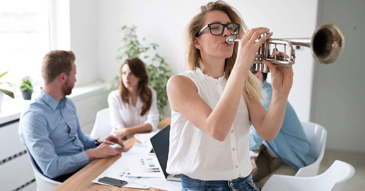 woman taking a break from a business meeting to play her trumpet